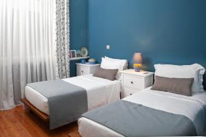 two beds in a room with blue walls at Avgi by the Sea in Kala Nera