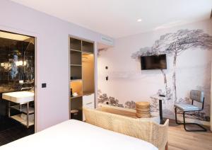 um quarto com uma cama e uma televisão na parede em Le Katorze Hôtel em Paris