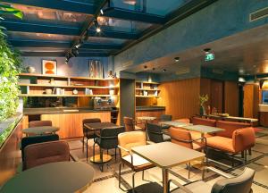 a restaurant with tables and chairs and shelves at Le Katorze Hôtel in Paris