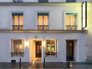 Edificio blanco con ventanas y balcón en Le Katorze Hôtel, en París