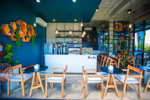 a restaurant with blue walls and tables and chairs at The one hotel สวนผึ้ง in Ratchaburi