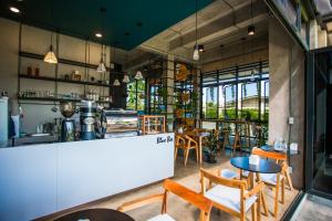 a restaurant with tables and chairs and a counter at The one hotel สวนผึ้ง in Ratchaburi
