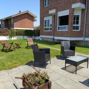 eine Terrasse mit Stühlen, einem Tisch und Blumen in der Unterkunft Magnificas vistas Alto de Laredo in Laredo