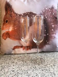dos copas de vino sentadas en una mesa con una ardilla en el fondo en L'Esquirol de L'Esquirol, en L’Esquirol