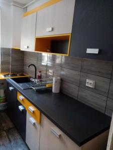 a kitchen with a sink and a black counter top at Mountain Loft in Piatra Neamţ +22 photos
