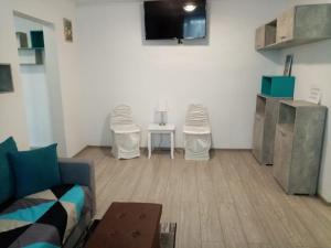 a living room with a couch and chairs and a tv at Mountain Loft in Piatra Neamţ