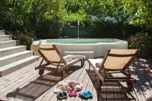 dwa krzesła i wanna z psem na tarasie w obiekcie Villa Erifili by Pelion Esties w mieście Agios Georgios Nilias