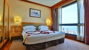 ein Hotelzimmer mit einem Bett und einem großen Fenster in der Unterkunft Crowne Plaza Hamra Beirut, an IHG Hotel in Beirut