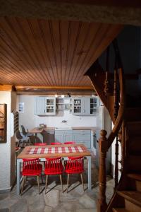 una cucina con tavolo e 4 sedie rosse di Villa Erifili by Pelion Esties a Agios Georgios Nilias