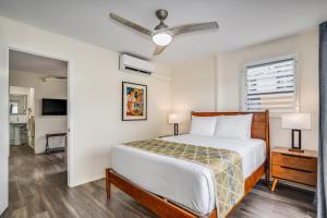 1 dormitorio con 1 cama y ventilador de techo en Aloha Suites Waikiki, en Honolulu