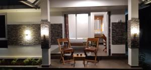 a living room with two chairs and a table at Greenberg cottages Mararikulam in Mararikulam +20 photos