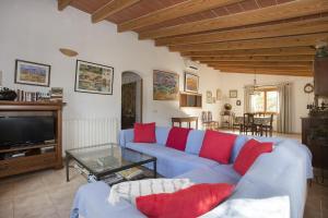 a living room with a blue couch and red pillows at Villa Servera in Santanyi
