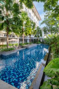 an image of a swimming pool in front of a building at Burza Hotel Yogyakarta in Yogyakarta