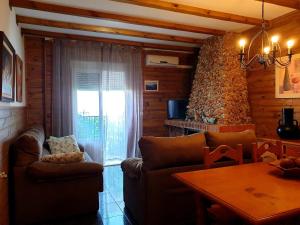 a living room with couches and a table and a window at Apartamentos El Parral in Arroyo Frio