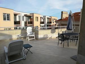 a patio with chairs and a table and an umbrella at Cozy family villa 500m. from the beach in Byala