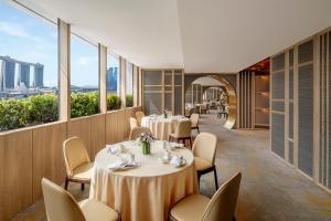 a restaurant with tables and chairs and windows at PARKROYAL COLLECTION Marina Bay, Singapore in Singapore