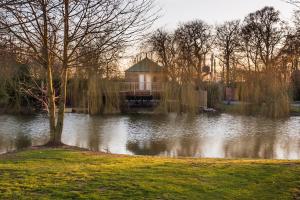 a lake with a house in the middle of it at The Treehouse - Sleeps 4 in Old Leake