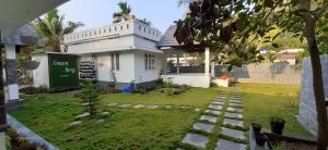 a house with a garden in front of it at Greenberg cottages Mararikulam in Mararikulam