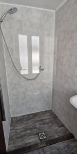 a shower with a glass door next to a sink at Location G&W, très proche sanctuaires in Lourdes