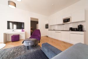 a living room with a couch and a purple chair at Modernes Apartment am Neumarkt in Dresden