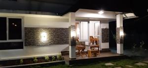 a house with two chairs and a table on a porch at night at Greenberg cottages Mararikulam in Mararikulam