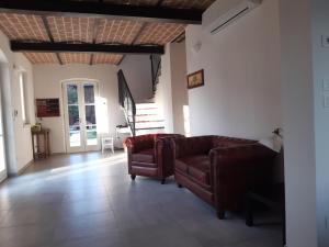 ein Wohnzimmer mit 2 Stühlen und einem Sofa in der Unterkunft SANTA MARIA DI LORGANA in Minerbio