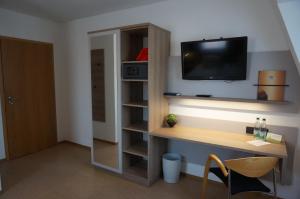 a room with a desk and a tv on a wall at Zenntaler Hof in Neuhof an der Zenn