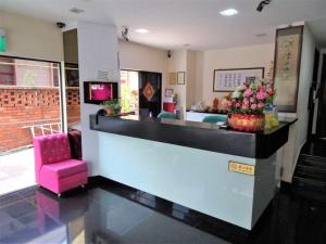 a lobby with a bar with a pink chair at SENG WAH HOTEL in Singapore
