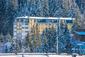 a yellow apartment building on a snow covered mountain at Sonnenwende by AlpenTravel in Bad Gastein