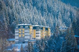a yellow building in the middle of a snow covered mountain at Sonnenwende by AlpenTravel in Bad Gastein