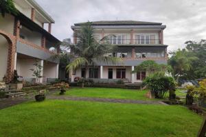 烏魯瓦圖的住宿－Pecatu GuestHouse，前面有绿色草坪的房子