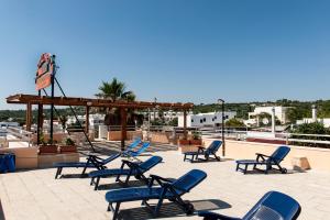 a group of blue chairs sitting on a patio at Hotel La Collinetta in Torre Vado +23 photos