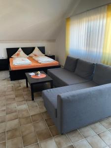 ein Wohnzimmer mit einem Sofa und einem Bett in der Unterkunft Zimmer in Lautrach in Lautrach