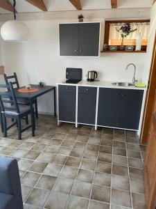 cocina con mesa, fregadero y encimera en Zimmer in Lautrach en Lautrach