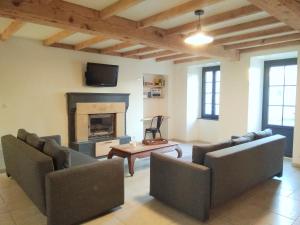 a living room with two couches and a fireplace at Gîte de l'Échaudi in La Réorthe