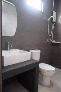 y baño con lavabo, aseo y espejo. en The one hotel สวนผึ้ง en Ratchaburi