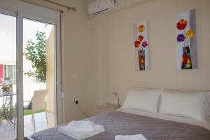 1 dormitorio con 1 cama y puerta corredera de cristal en Villa Nopigia Homeleader en Nopíyia
