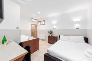Pokój hotelowy z łóżkiem, biurkiem i pokojem w obiekcie Argyle Apart Hotel w Londynie