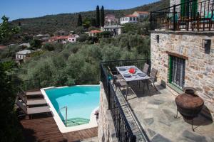 Áno GatzéaにあるVilla Thalia by Pelion Estiesのプールとバルコニーのテーブルを備えたヴィラ