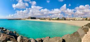 widok na plażę z budynkami w tle w obiekcie Casa Monny Fuerteventura Holiday Wi-Fi w mieście Puerto del Rosario