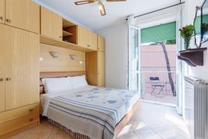 ein Schlafzimmer mit einem Bett und einem großen Fenster in der Unterkunft Lido Degli Estensi Flat con Balcone e Parcheggio! in Lido degli Estensi