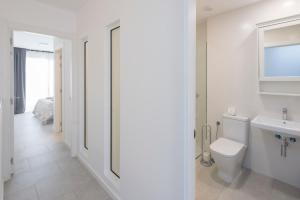 ein weißes Bad mit einem WC und einem Waschbecken in der Unterkunft Casa Reina in Playa Blanca