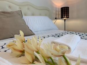 Una cama con un ramo de flores blancas. en Affittacamere Il Borgo, en Levanto