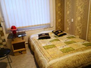 una camera da letto con un letto con una trapunta sopra di KAMBARIŲ nuoma Kaune - a Kaunas