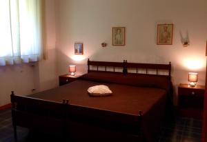 1 dormitorio con 1 cama y 2 lámparas en 2 mesas en Serena Rustic en Ledro