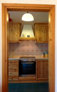 una cucina con armadi in legno e piano cottura. di Serena Rustic a Ledro