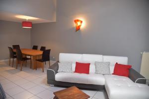 a living room with a white couch with red pillows at Le cerisier in Kaysersberg