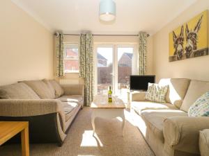 a living room with two couches and a table at 8 Adams Meadow in Ilminster