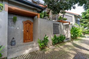 a house with a wooden door on the side of it at Omah Sabin Villa East in Canggu