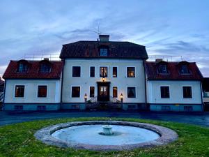Tokeryds Herrgård في يونيشوبينغ: منزل أبيض كبير مع نافورة في الفناء